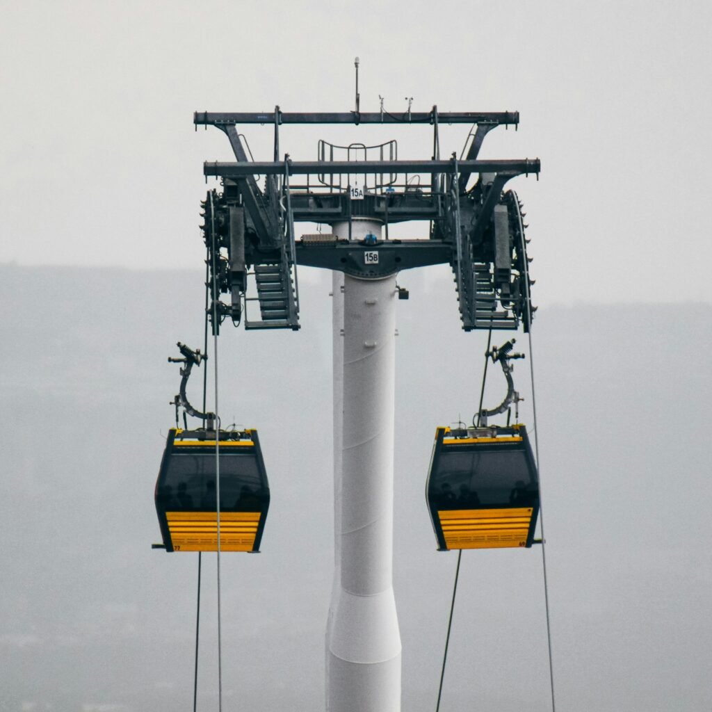 A cable car system with gondolas in a foggy outdoor setting, showcasing industrial design.