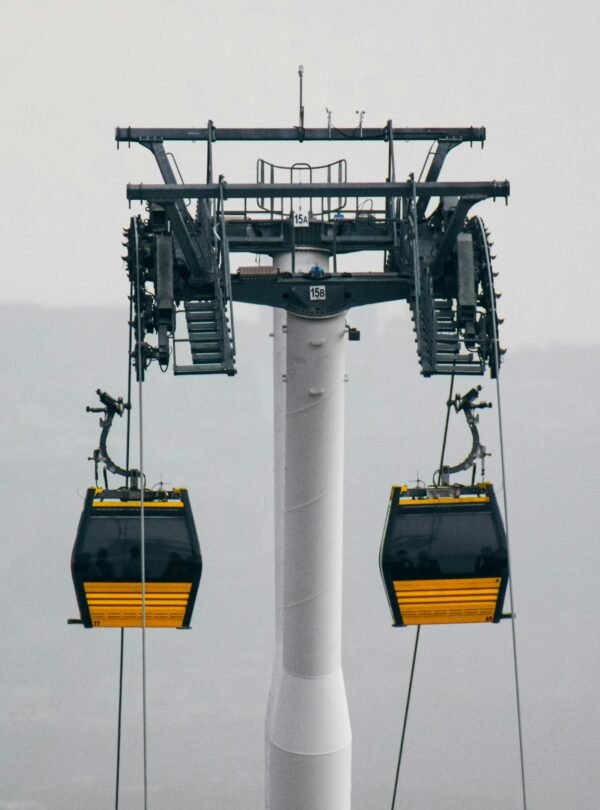 A cable car system with gondolas in a foggy outdoor setting, showcasing industrial design.