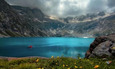 Stunning view of a tranquil lake surrounded by mountains in Kumrat Valley, Pakistan.