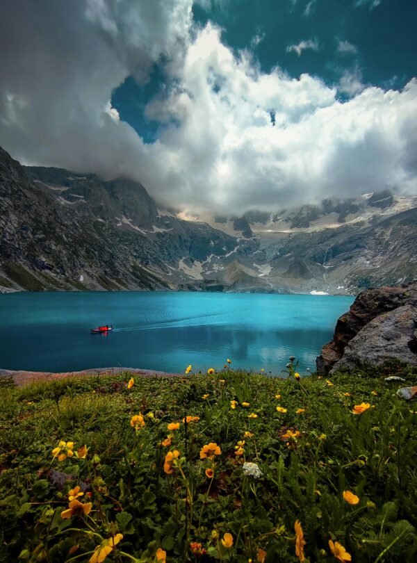 Stunning view of a tranquil lake surrounded by mountains in Kumrat Valley, Pakistan.