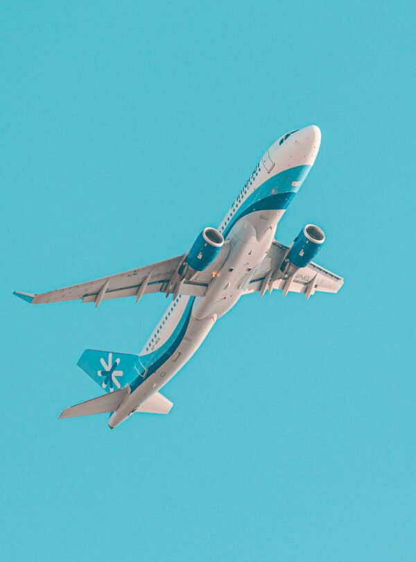 A low angle shot of an airplane flying through a clear blue sky in Karachi, Pakistan.